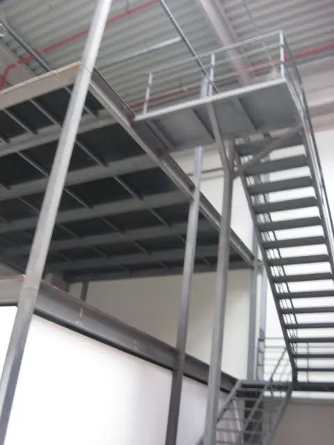 Stahlbühne mit Industrietreppe und Geländer in einer Lagerhalle