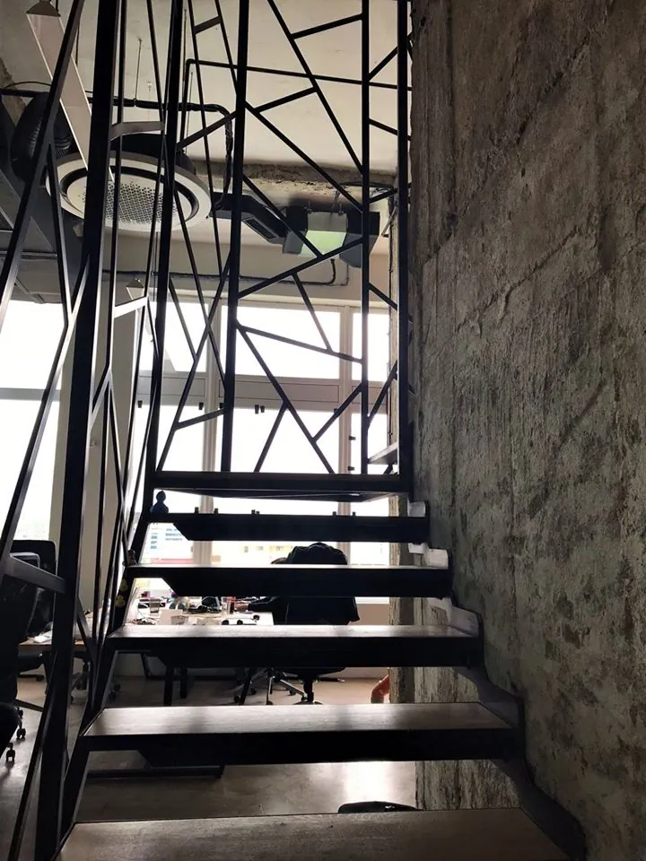 Stahltreppe mit offenen Stufen und geometrischem Stahlgeländer im Büro