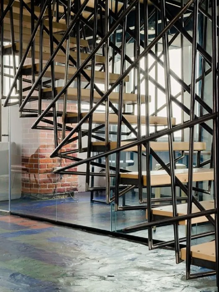 Stahltreppe mit Holzstufen und geometrischem Stabgeländer